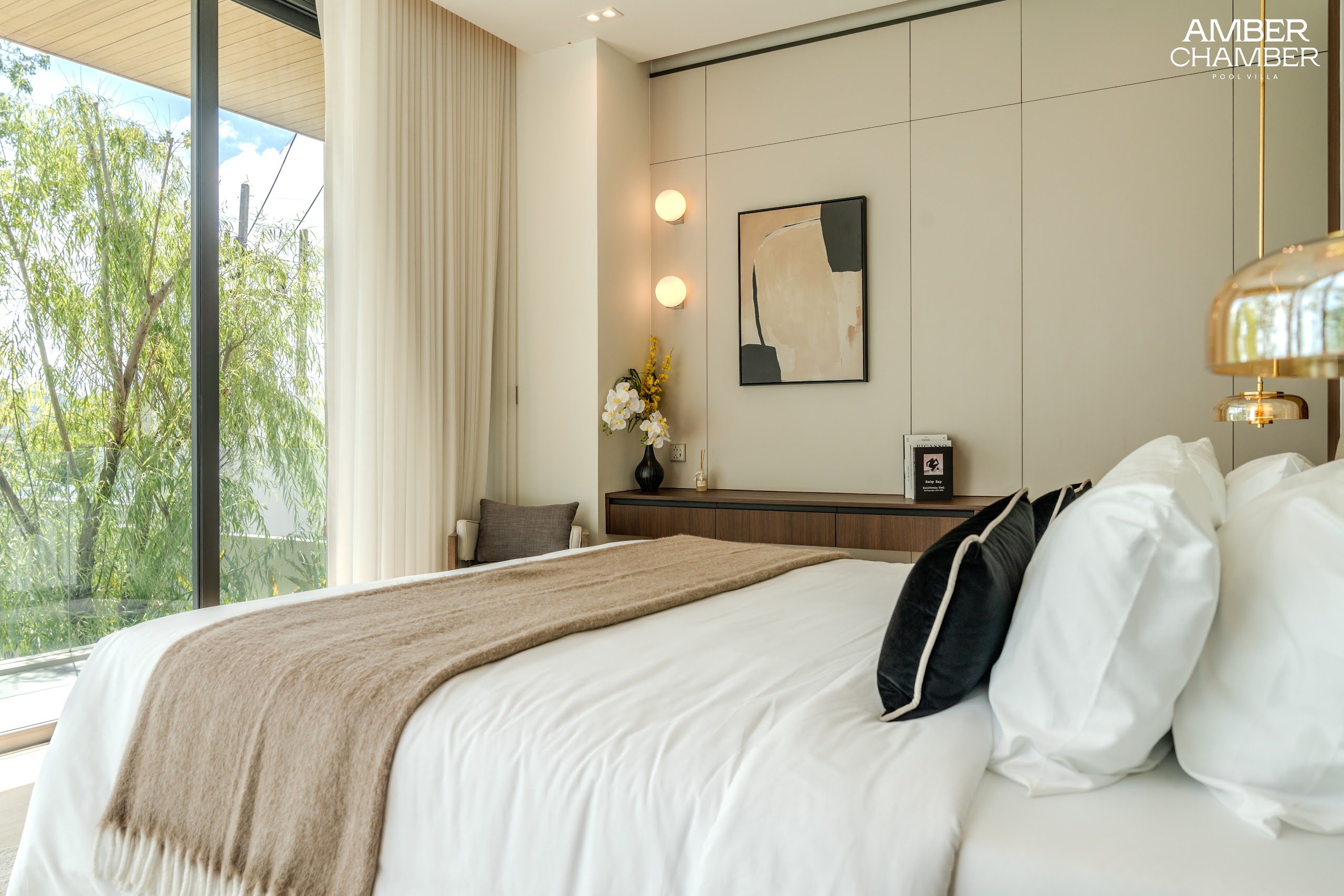 Amber Chamber villa bedroom with timber joinery and layered bed linen