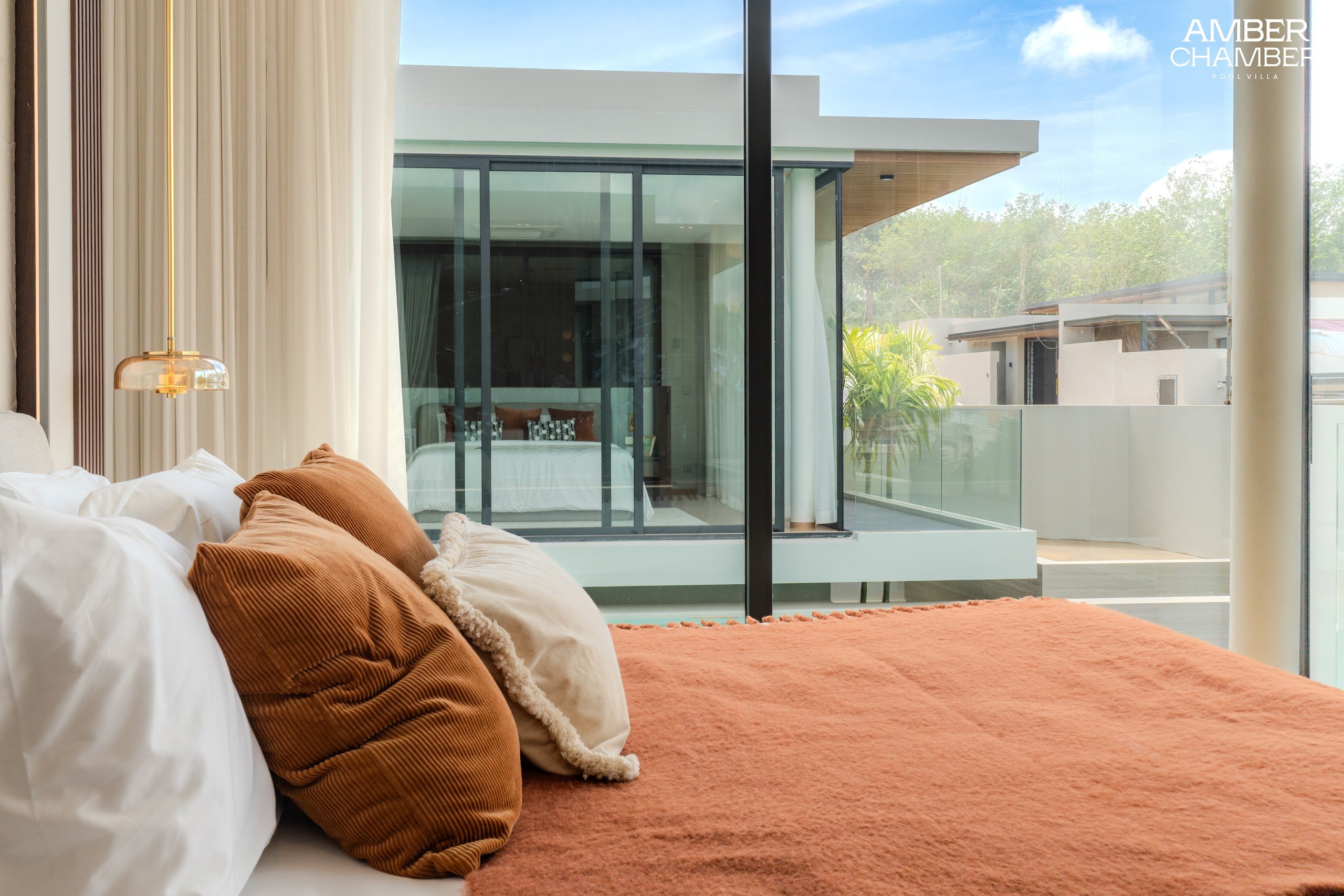 Amber Chamber villa bedroom with timber joinery and layered bed linen