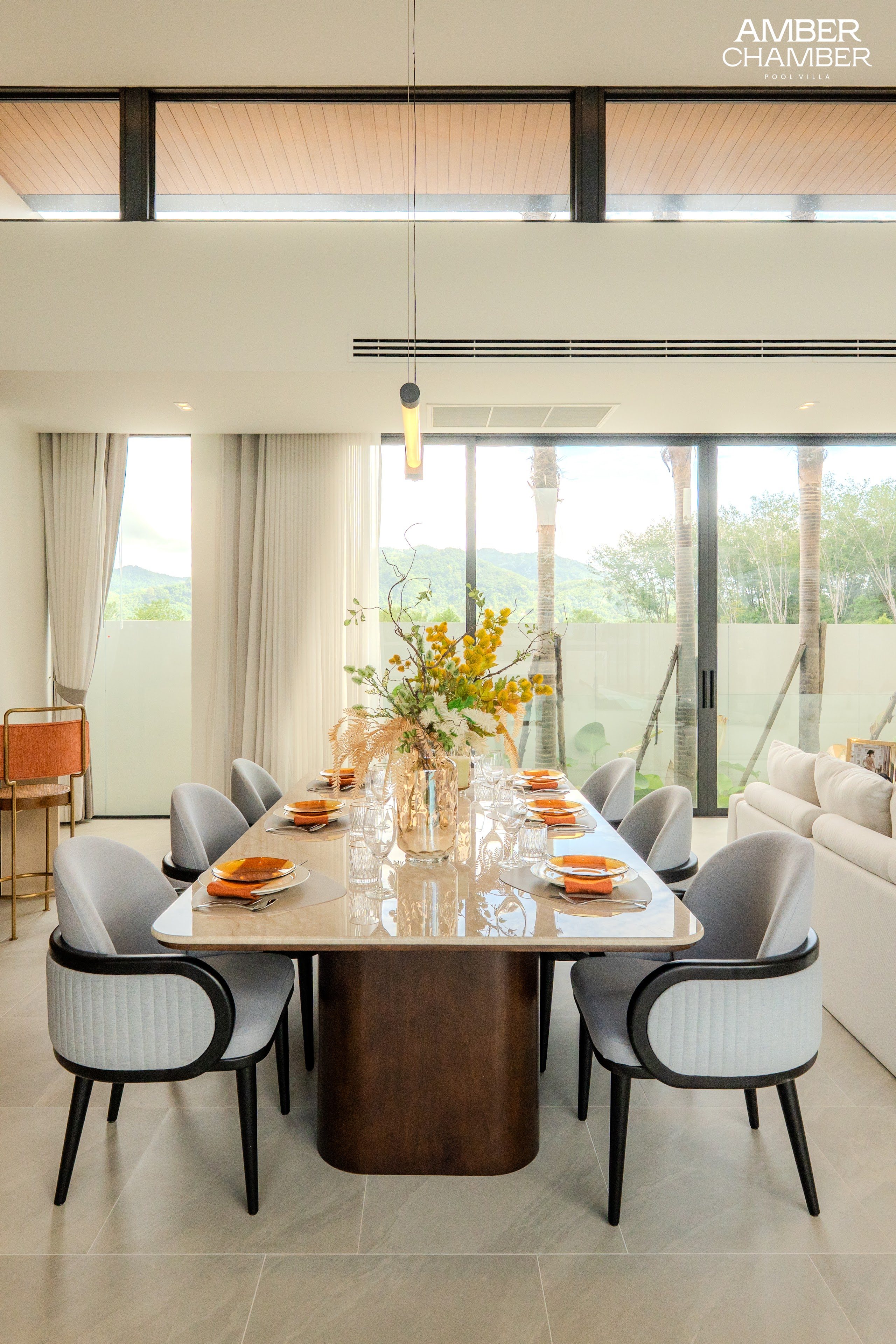 Open-plan living and dining area inside an Amber Chamber pool villa