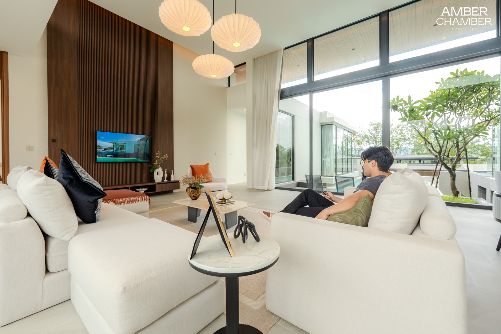 Bright living room with floor-to-ceiling windows overlooking greenery