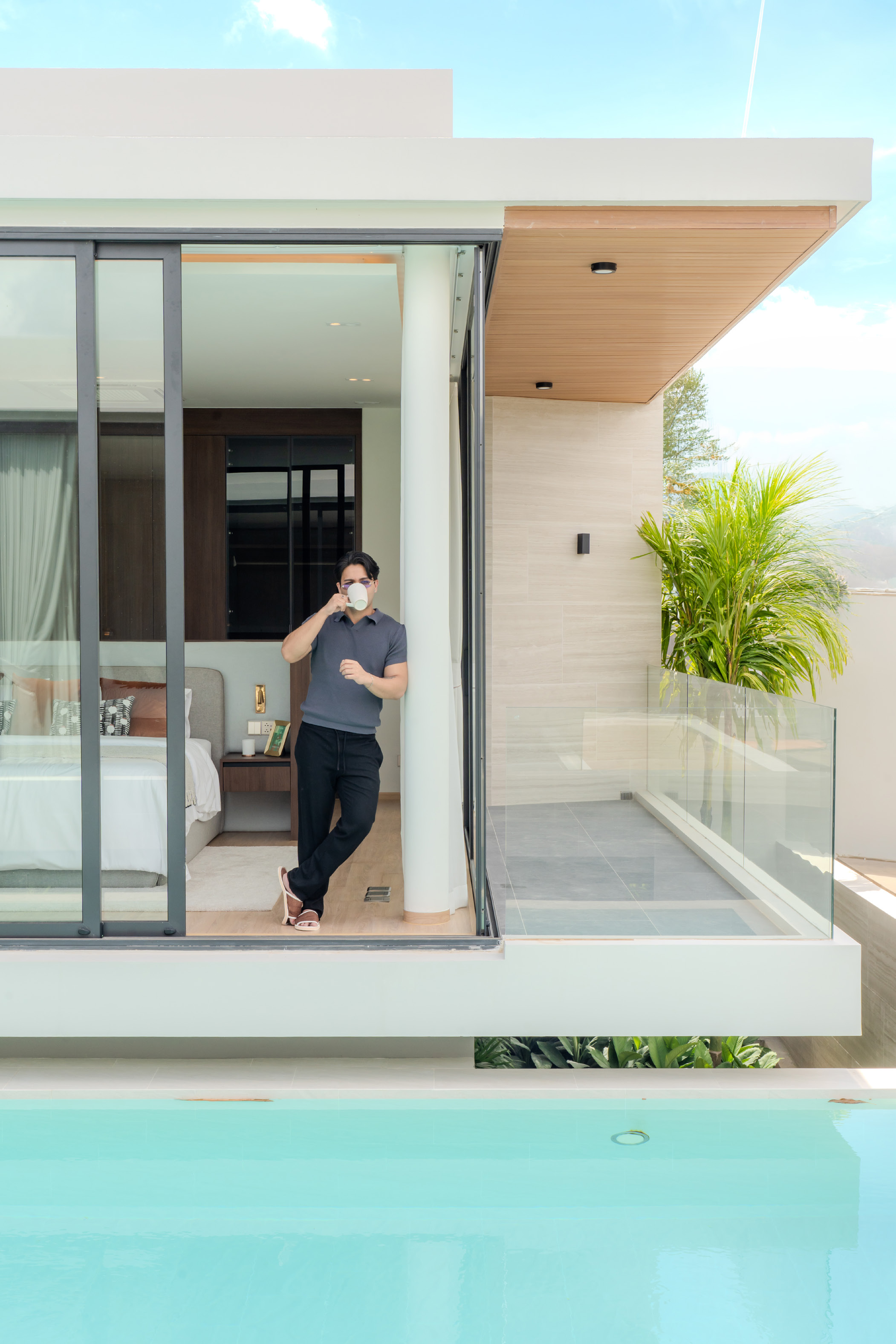 Poolside balcony framed by full-height glass doors